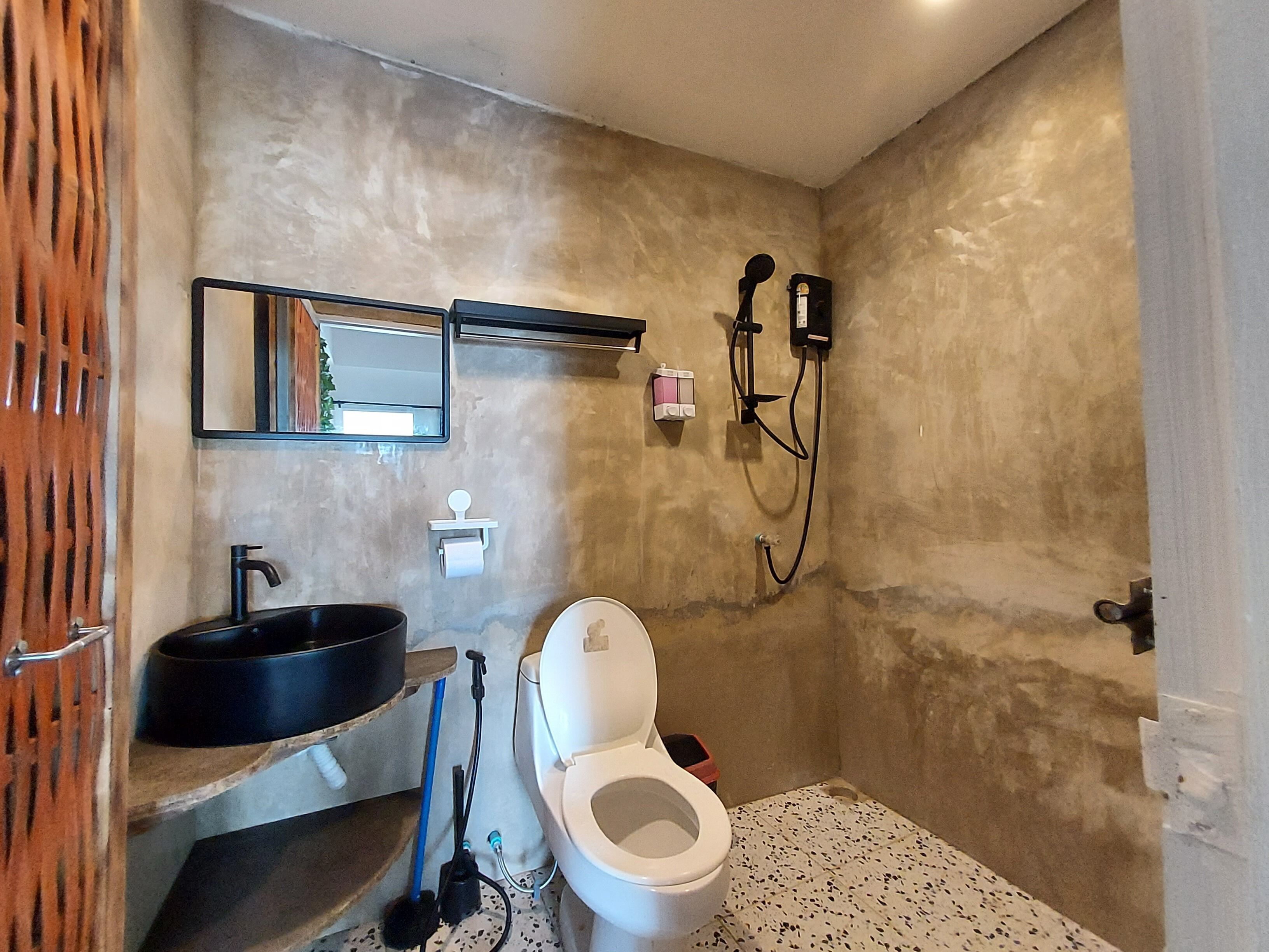 Une salle de bain avec un lavabo, des toilettes et une douche.