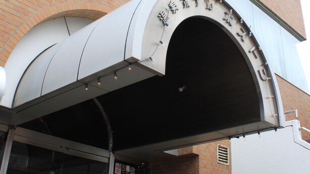 The exterior of the Hotel Boston Building with a prominent arched entrance and signage. - Hot Spring Hotel Boston (Obihiro)