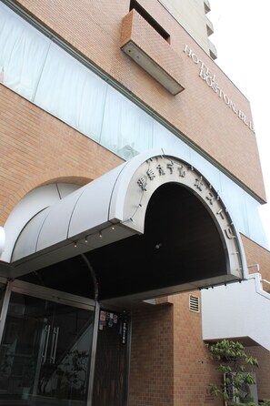 The exterior of the Hotel Boston Building with a prominent arched entrance and signage. - Hot Spring Hotel Boston (Obihiro)
