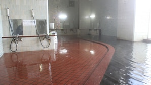 A wet tiled floor with a red border, a handwashing station, and a mirror. - Hot Spring Hotel Boston (Obihiro)