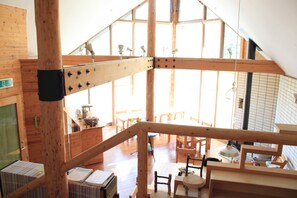 A spacious wooden interior with high ceilings and a mezzanine level. - Pension Gooseberry (Furano)