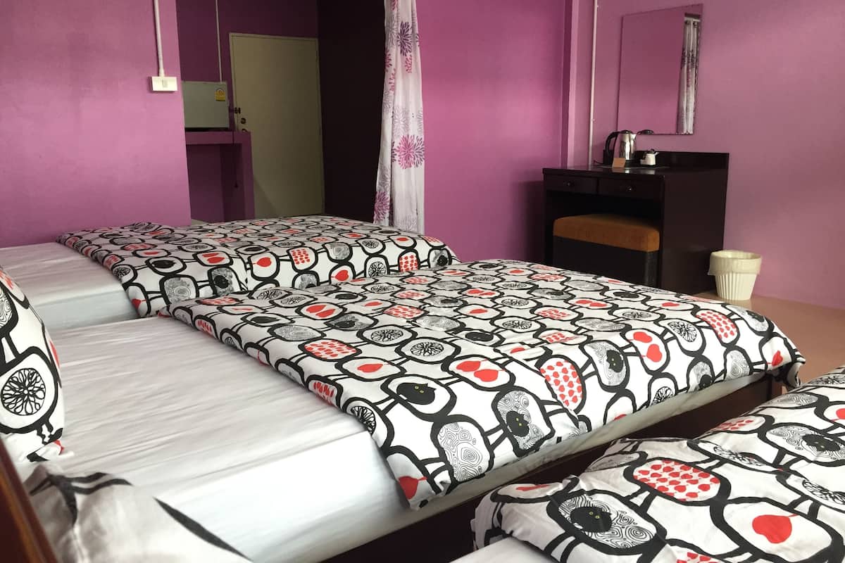 A room with two beds, a desk, and a mirror.