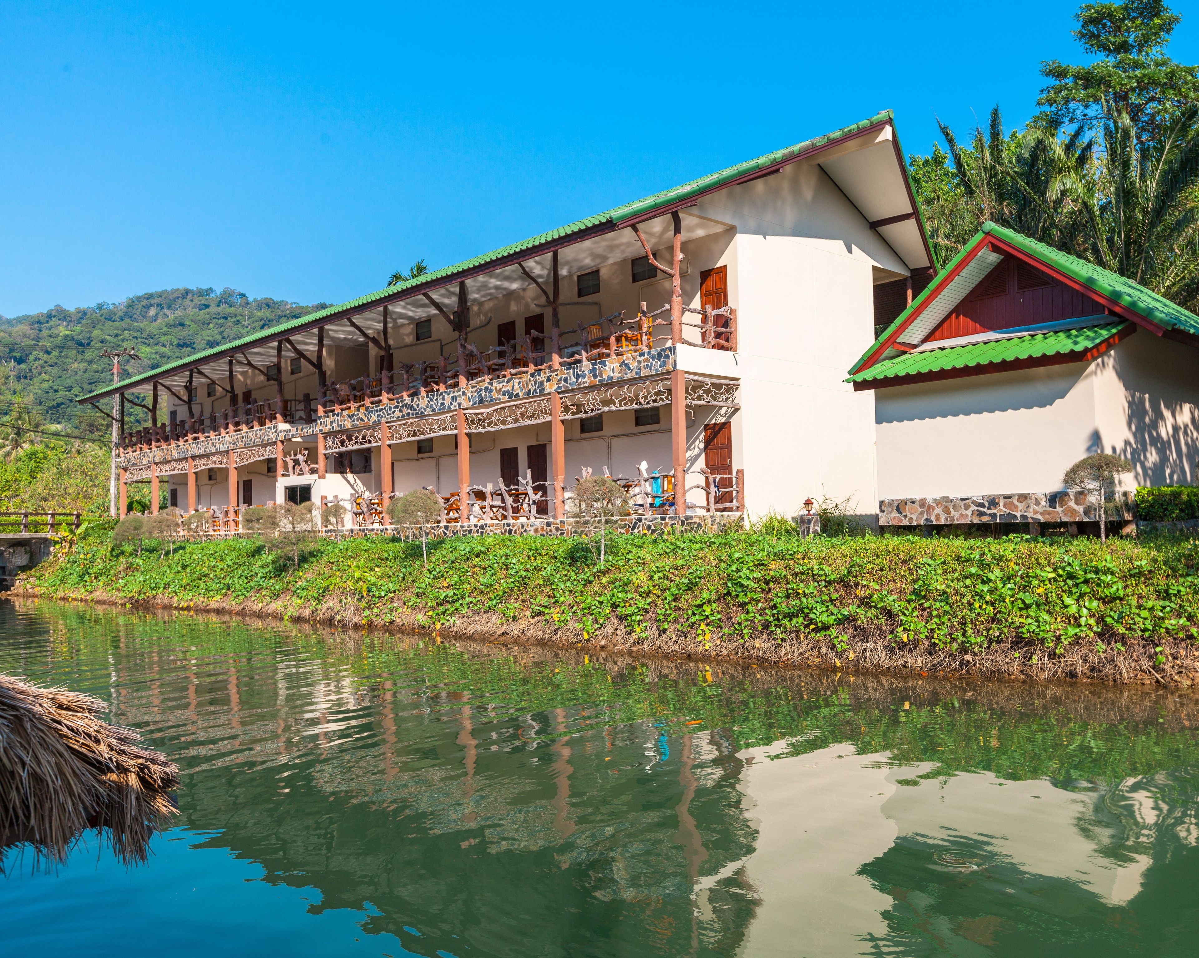 A two-story building with a balcony, located beside a body of water.
