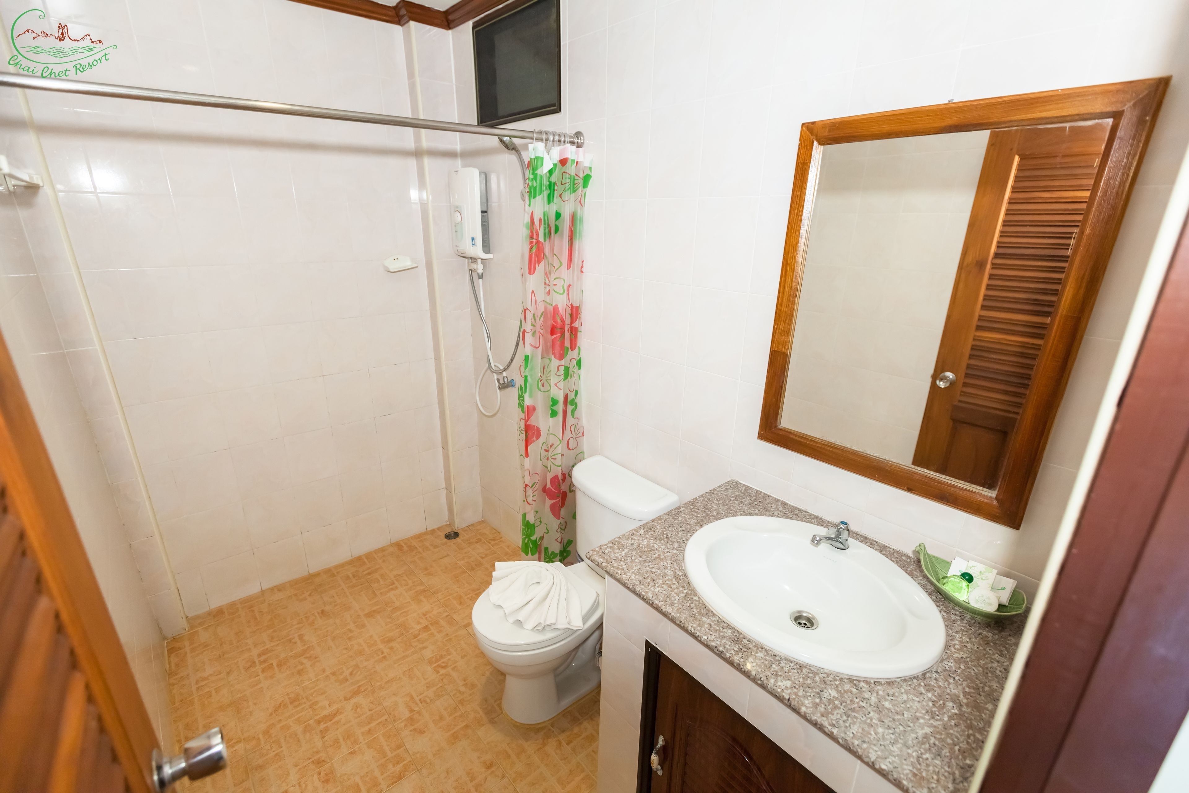 Baño con ducha, inodoro, lavabo y espejo.