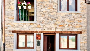A stone building with a tiled roof, two windows, and a door. - Casa Rural Antonio (Vitigudino)
