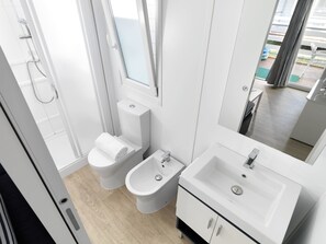 Un baño moderno con inodoro, bidé y lavamanos.