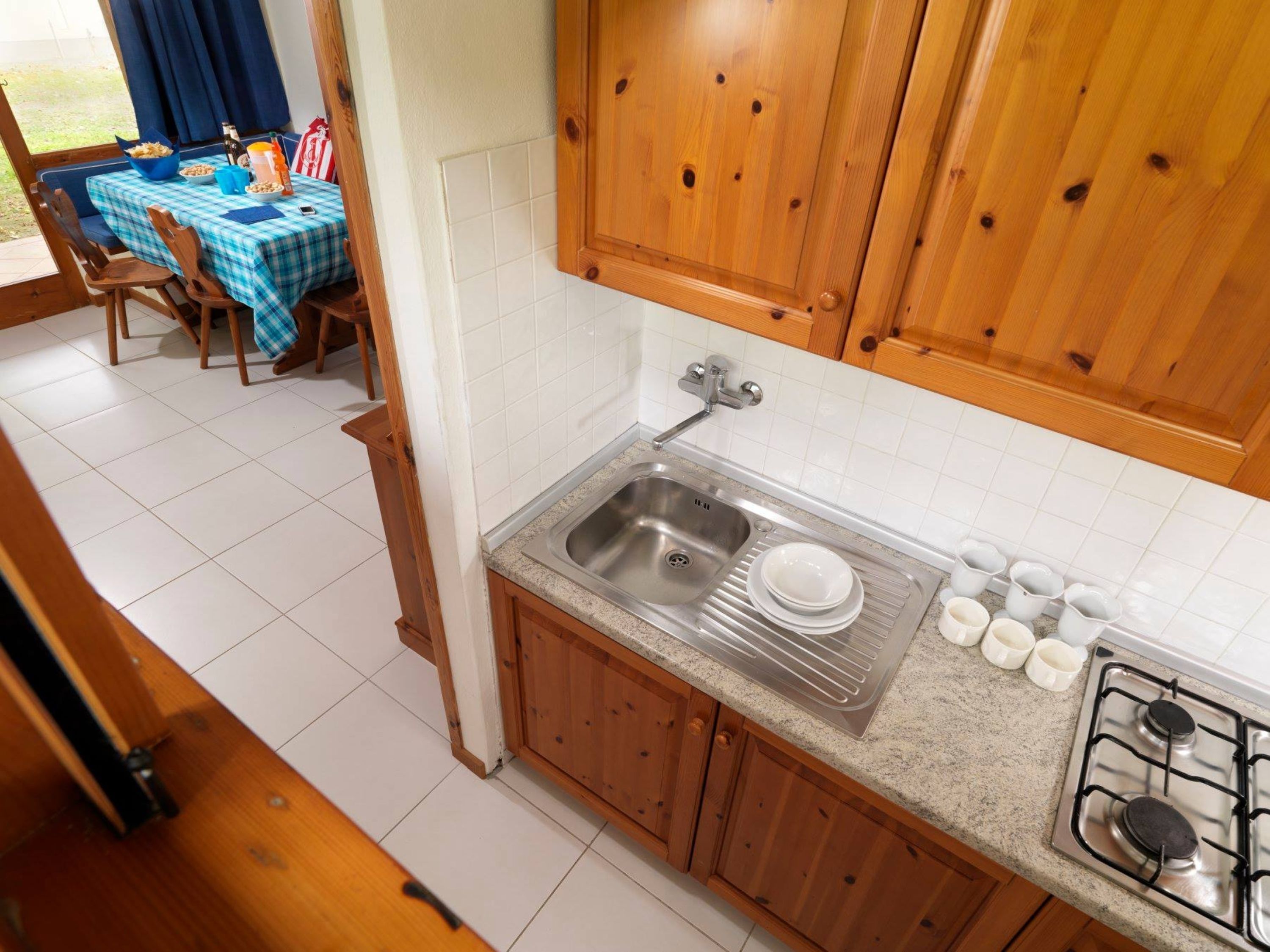 A kitchen with wooden cabinets, a stainless steel sink, and a gas stove.