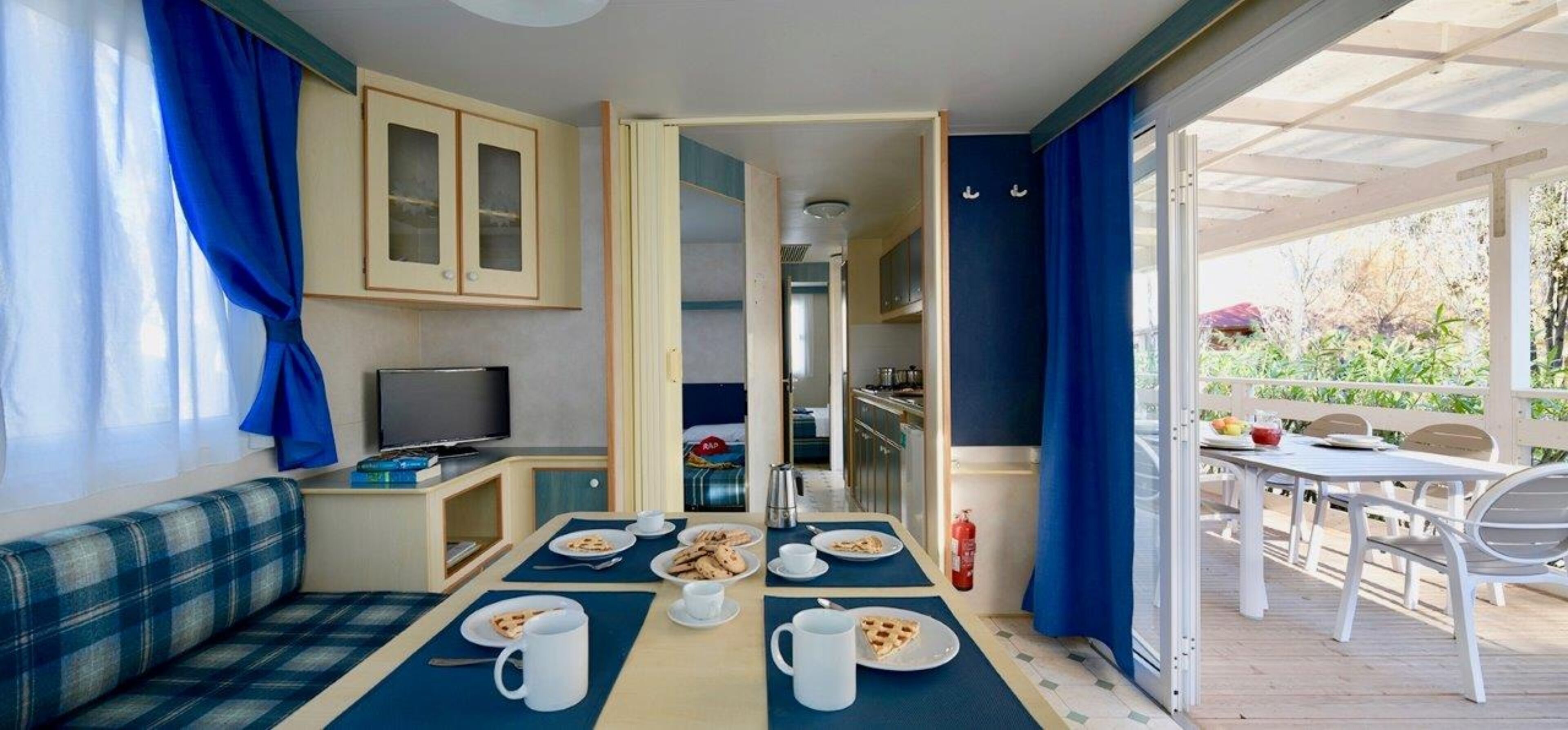Une pièce comprenant un coin repas, un téléviseur et une kitchenette.