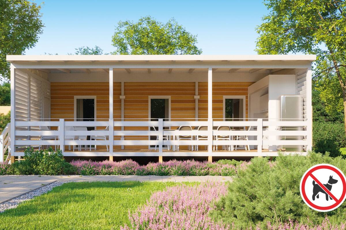 A modern building with a covered porch, white railings, and a no dog sign.