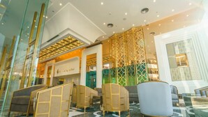 Um hall com assentos modernos, balcão de recepção e painéis decorativos.