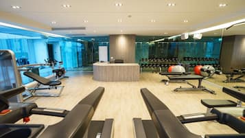 A modern gym with treadmills, weight machines, and exercise balls.