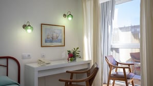 A room with a bed, a desk with a telephone, a framed picture, and two chairs. - Hotel La Ruta (Tapia de Casariego)