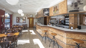 A café with a counter, stools, and tables. - Hotel La Ruta (Tapia de Casariego)