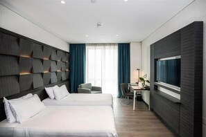 A modern hotel room with a large bed, a desk with a chair, a TV, and a window with curtains. - Wish More Hotel Istanbul (Istanbul)