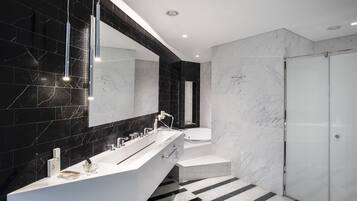 A modern bathroom with a large white bathtub, a separate shower area, and a vanity with a mirror.