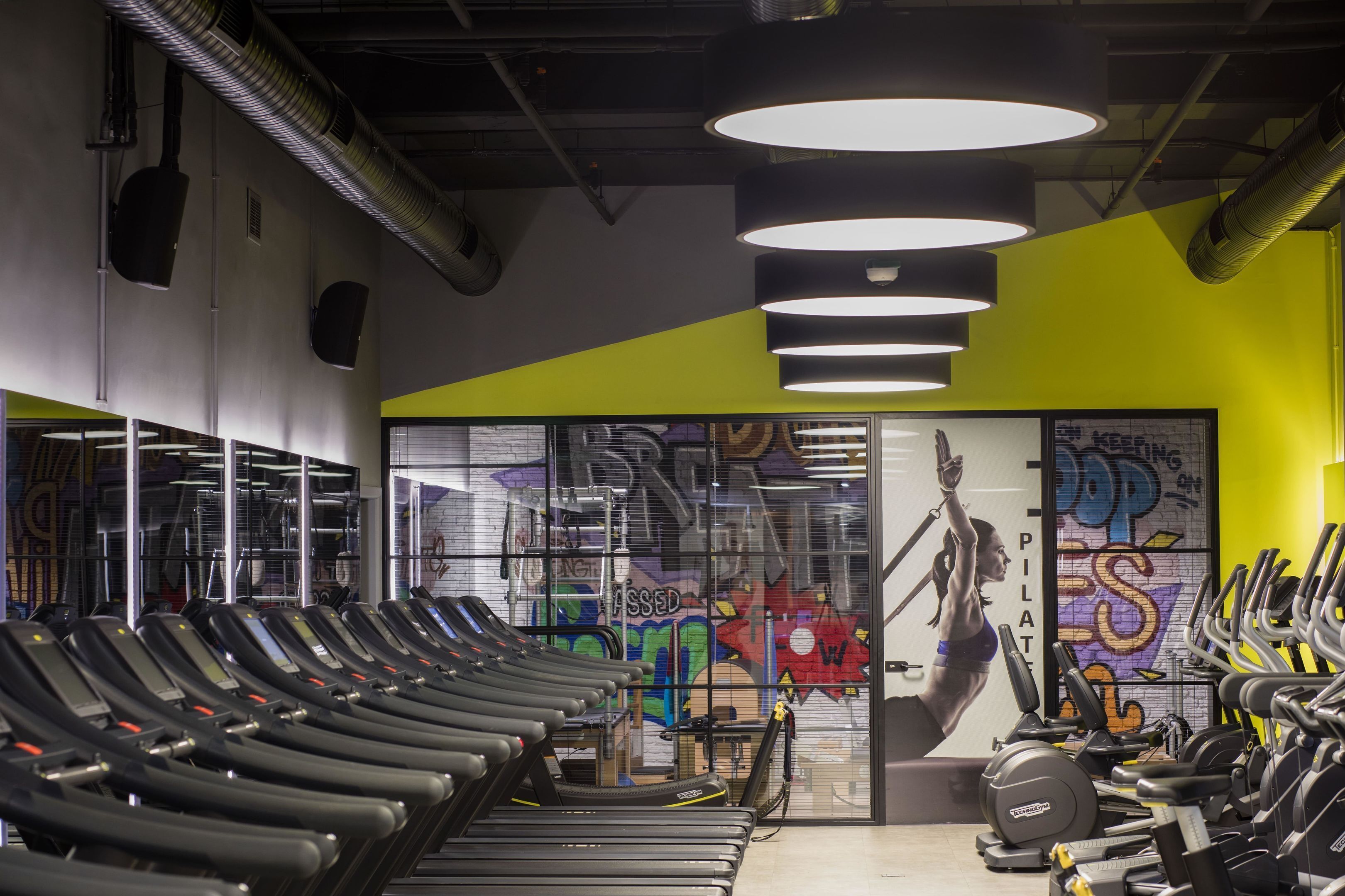 Une salle de sport équipée de tapis de course, de vélos d’appartement et d’appareils de musculation.