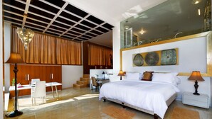 Un dormitorio moderno con una cama grande, un escritorio y una silla. Una escalera conduce a un nivel superior.