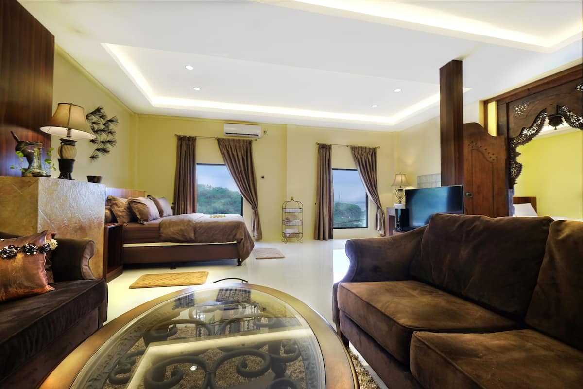 A spacious living room with a sofa, a glass coffee table, and a TV.