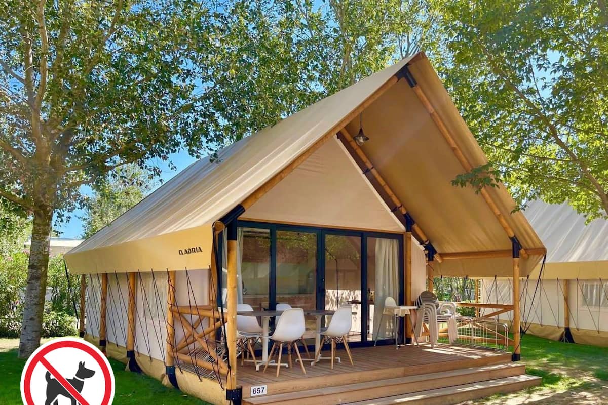 A tented accommodation with a dining area, a no-pet sign, and a number 657.