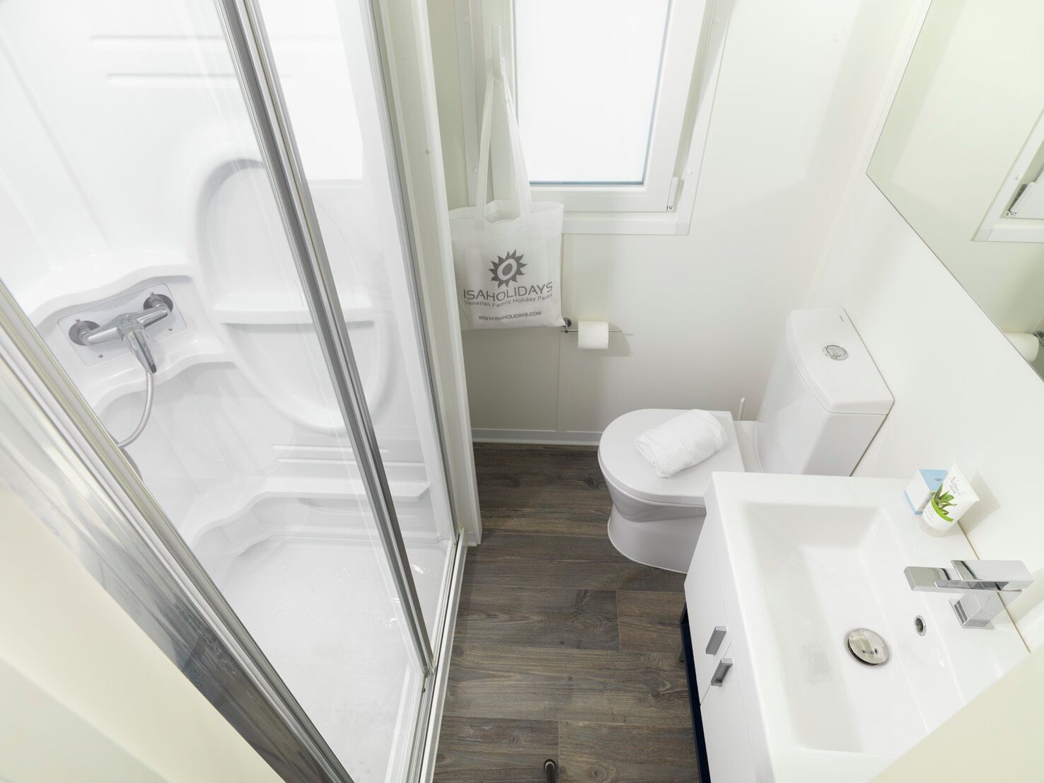 Et moderne badeværelse med bruser, toilet og vask.