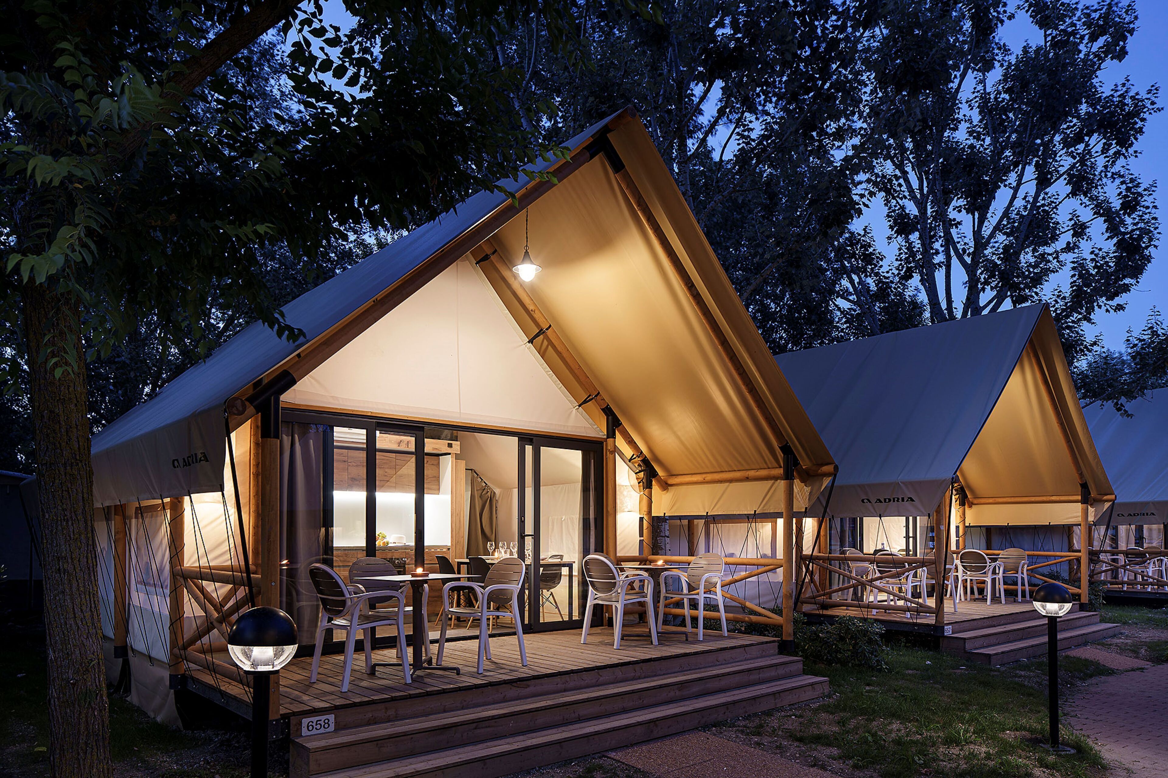 A tented accommodation with a dining area and seating.