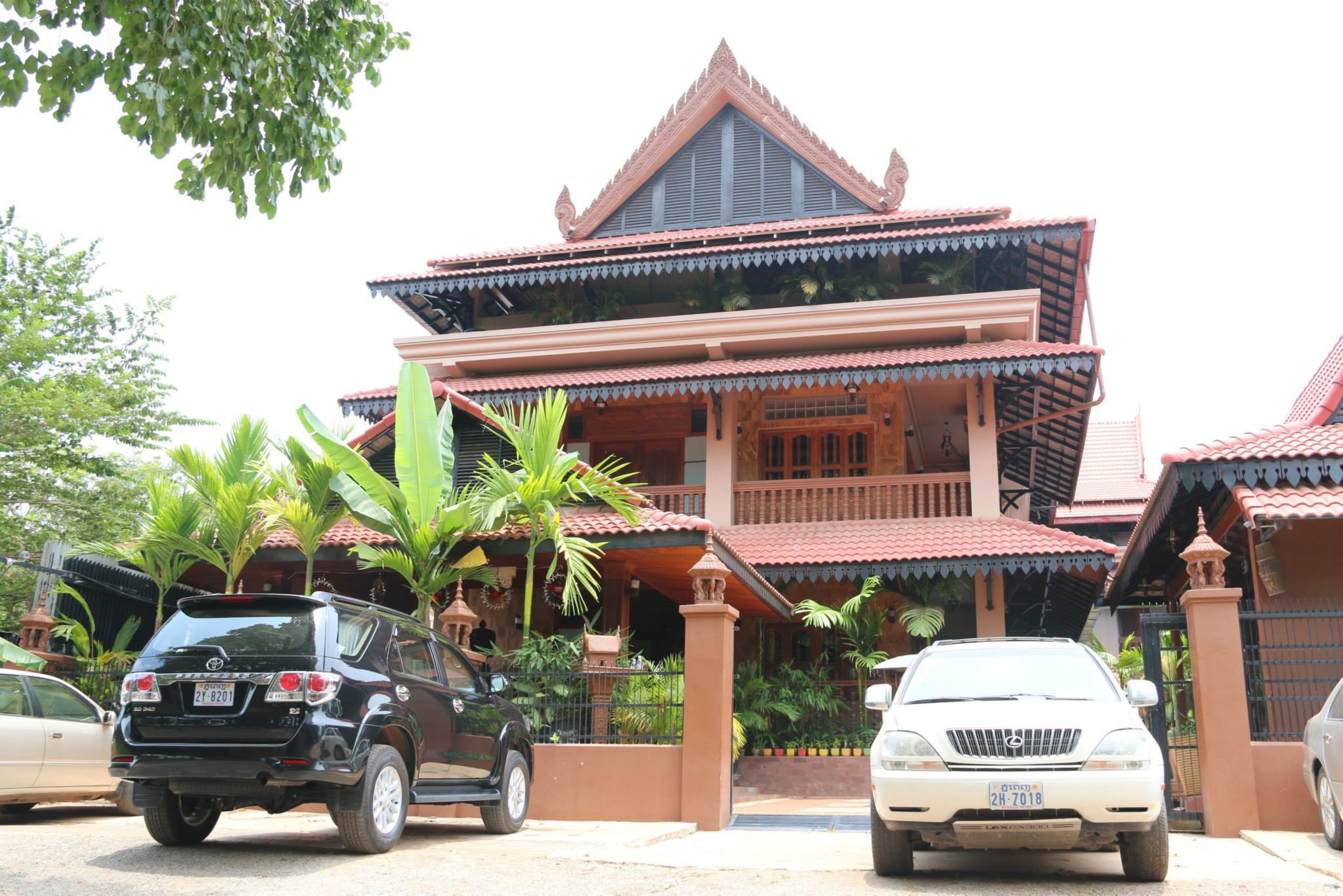 A traditional multi-story house with a red tiled roof and a balcony.