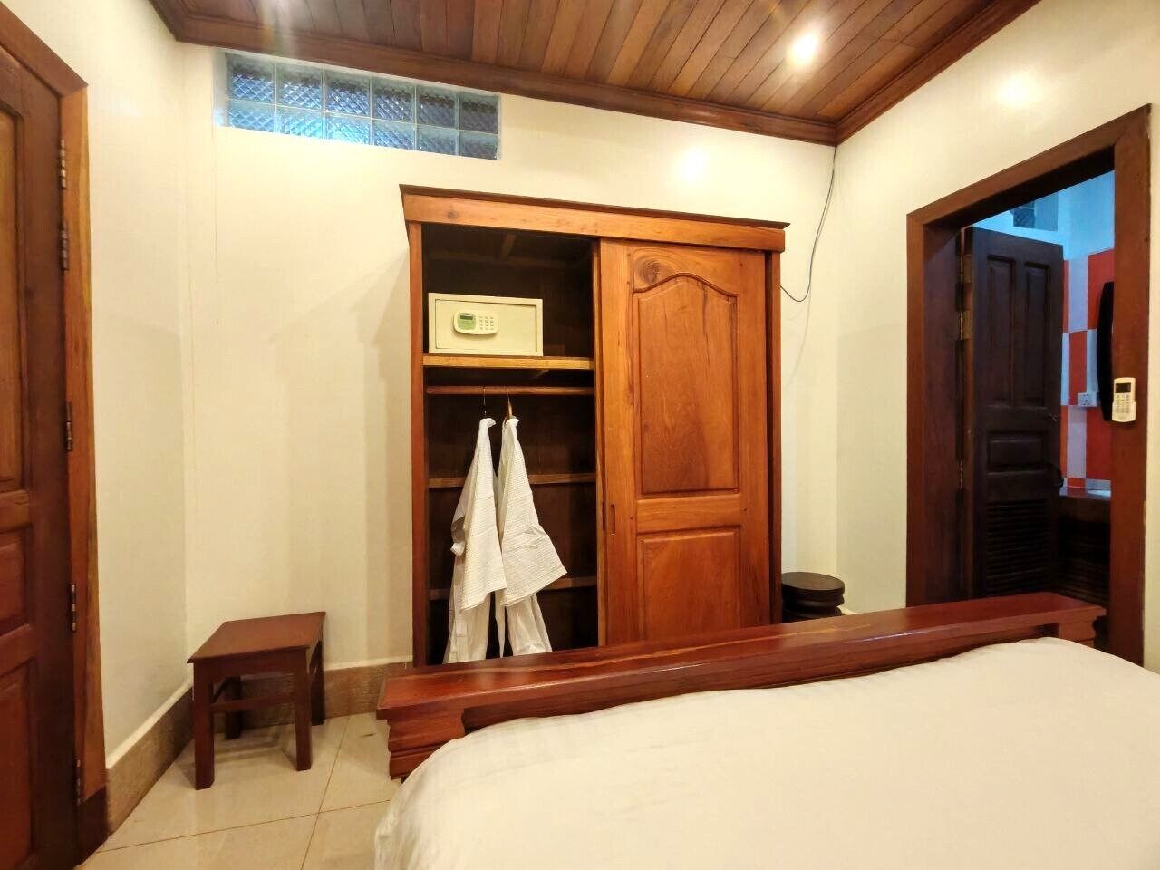 Una camera da letto con un letto, un armadio in legno e un tavolino.