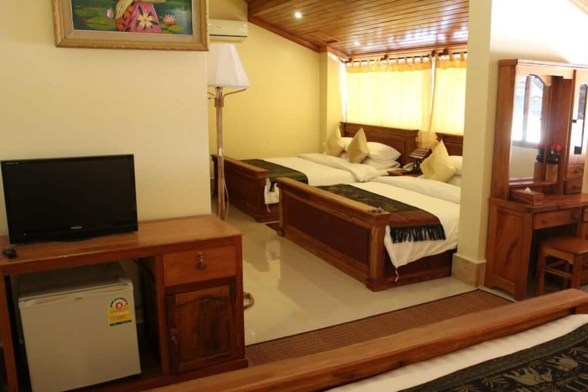 Une chambre d’hôtel équipée d’un lit, d’une télévision, d’un petit réfrigérateur, d’un bureau et d’un miroir.