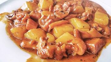 A dish of chicken and potatoes in a thick sauce.
