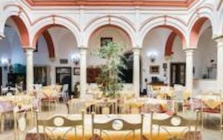 A spacious indoor area with multiple tables and chairs, arranged in a semi-circular fashion.