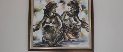 Un tableau encadré représentant deux personnages assis sur un banc.
