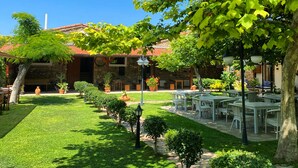 A courtyard with a stone building, outdoor seating, and well-maintained greenery. - Armagrandi Bozcaada (Bozcaada)