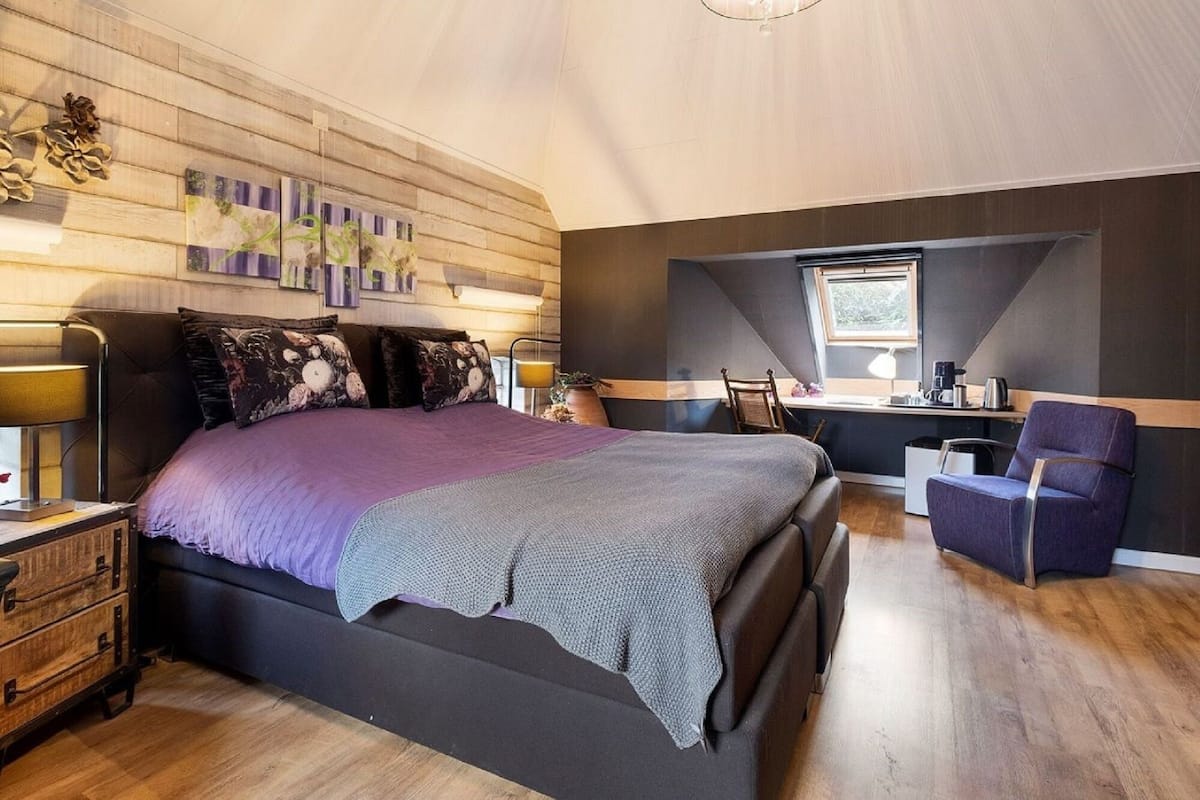 Une chambre à coucher avec un grand lit, un bureau et une chaise.