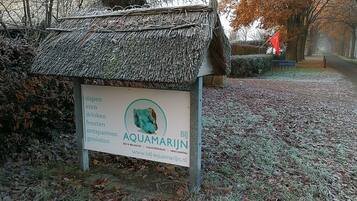 A sign for a bed and breakfast named 'AQUAMARJIN' with amenities listed including sleeping, eating, drinking, feasting, and renting.