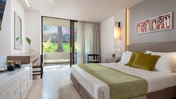 Una habitación de hotel moderna con una cama grande, un escritorio con silla, una mesita de noche y vistas al exterior.