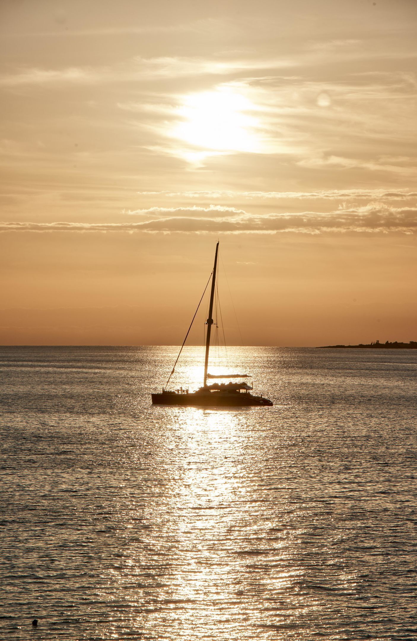 A sailboat on calm waters during sunset.