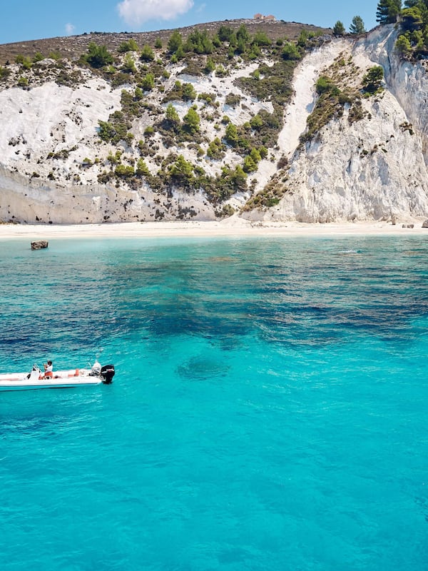 Experience the tranquility of the turquoise sea and rocky coastline, perfect for water activities.