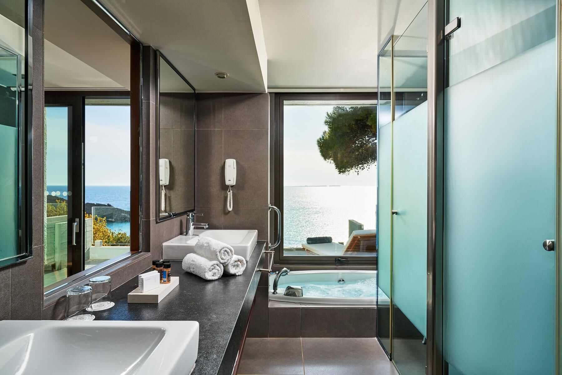 A modern bathroom with a large bathtub, a separate shower area, and a vanity with a sink and towel rack.