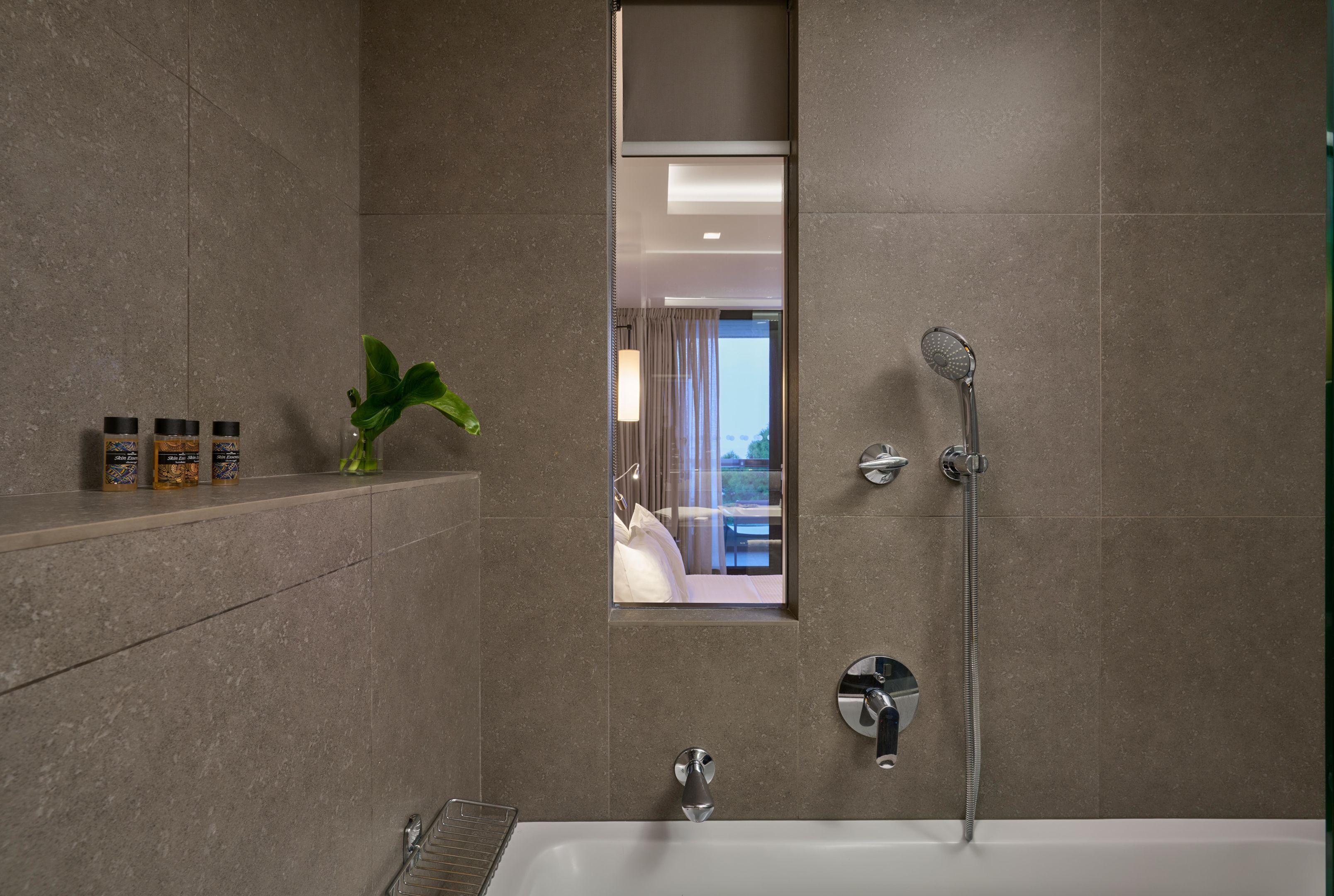 A modern bathroom with a bathtub, shower, and a mirror.