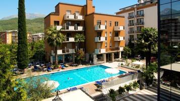 Un hotel con piscina, diversi balconi e vista sul paesaggio circostante.