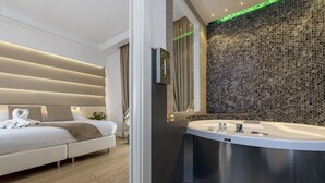 A modern bedroom with a large bed, a built-in vanity with a bathtub, and a textured wall.