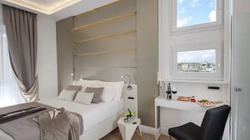 Una moderna camera d'albergo con un letto, un comodino e una scrivania con vista sulla città.