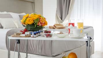 Ontbijt met toast, fruit en sap op een tafeltje in een hotelkamer.