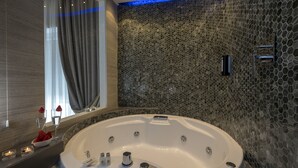 A modern bathroom with a large bathtub, a mirror, and a mosaic wall. - Vatican Style (Rome)