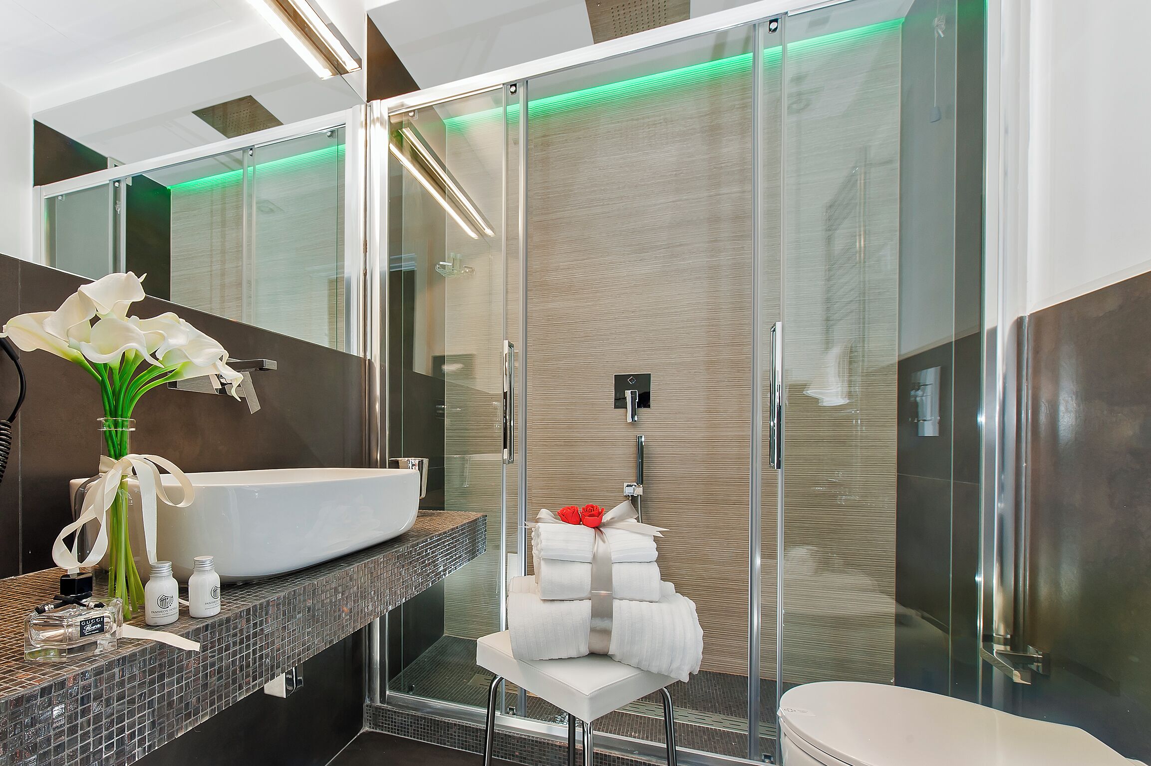Un baño moderno con un lavamanos grande blanco, una cabina de ducha de vidrio y un inodoro blanco.
