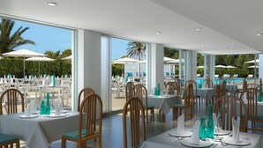 A restaurant with tables set for dining, overlooking a pool area. - BQ Sarah Hotel - Adults Only (Santa Margalida)