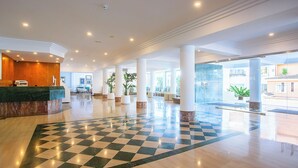A spacious lobby with a checkered floor, a reception desk, and large windows allowing natural light. - BQ Sarah Hotel - Adults Only (Santa Margalida)