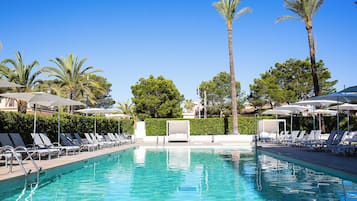 Una piscina al aire libre, sombrillas, sillones reclinables de piscina