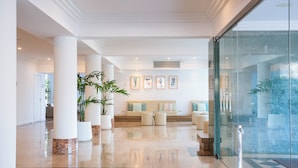 A spacious lobby with a checkered floor, a seating area with cushions, and potted plants. - BQ Sarah Hotel - Adults Only (Santa Margalida)