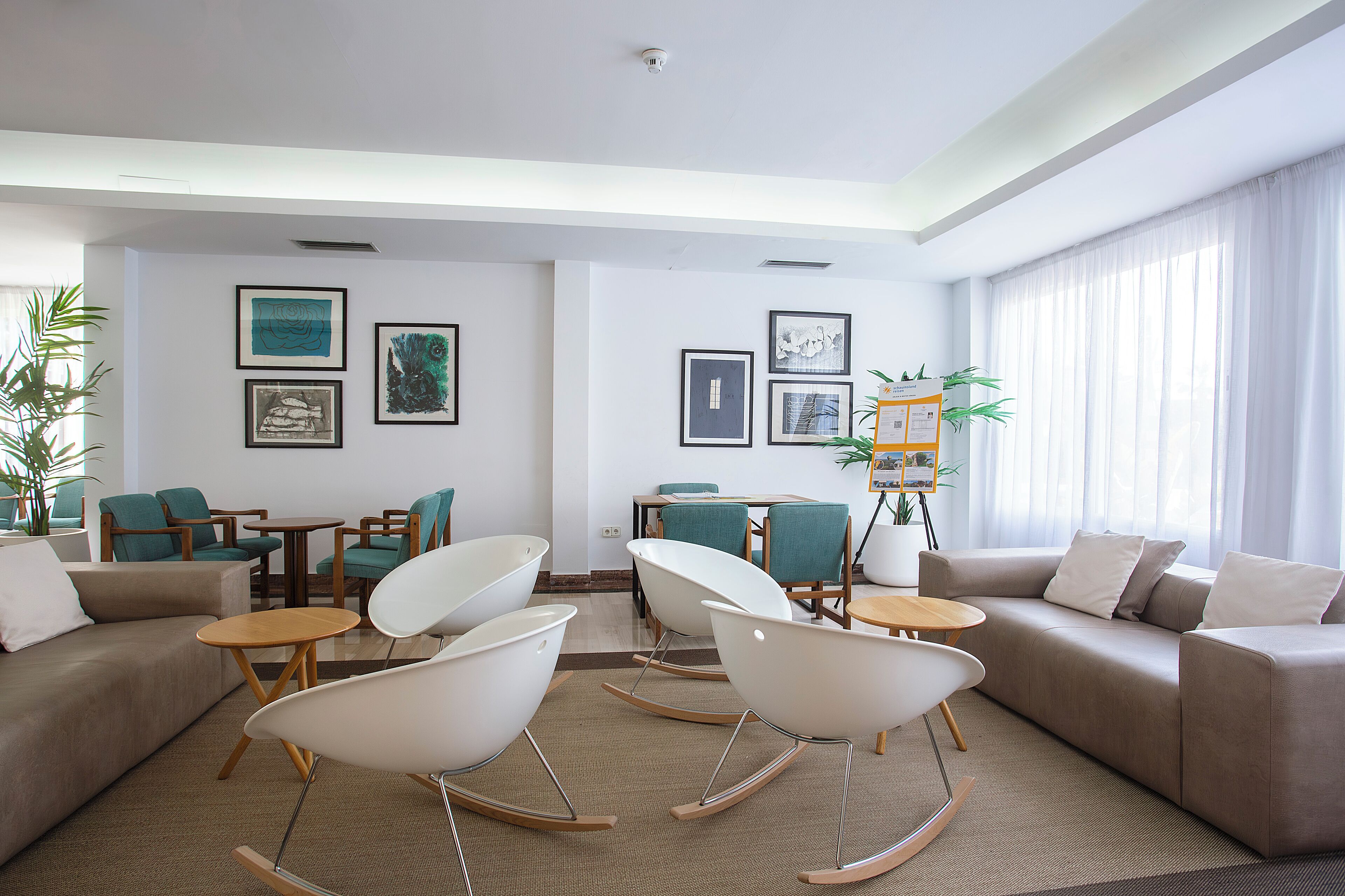 Una sala de estar moderna con un sofá, sillas, una mesa de centro y un comedor.